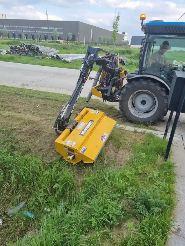 Maaiarm in werkpositie naast een industriële berm